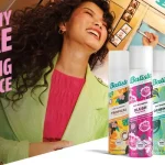 Bright ad banner for Batiste dry shampoo with tropical cans and two smiling women in colorful outfits